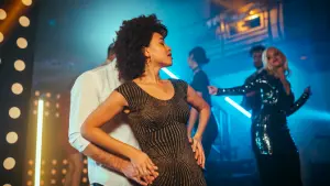 Panoramica di una sala da ballo affollata con ballerini di salsa di vari stili.