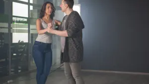 Ballerini eseguono passi eleganti di salsa portoricana, con movimenti fluidi e sincronizzati, in un ambiente festoso
